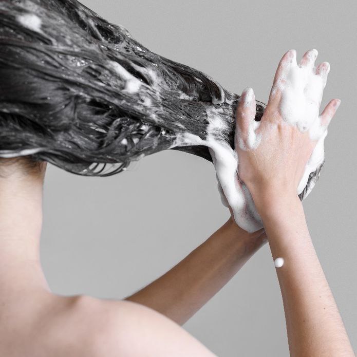 Applying conditioner to moisturize and protect hair.