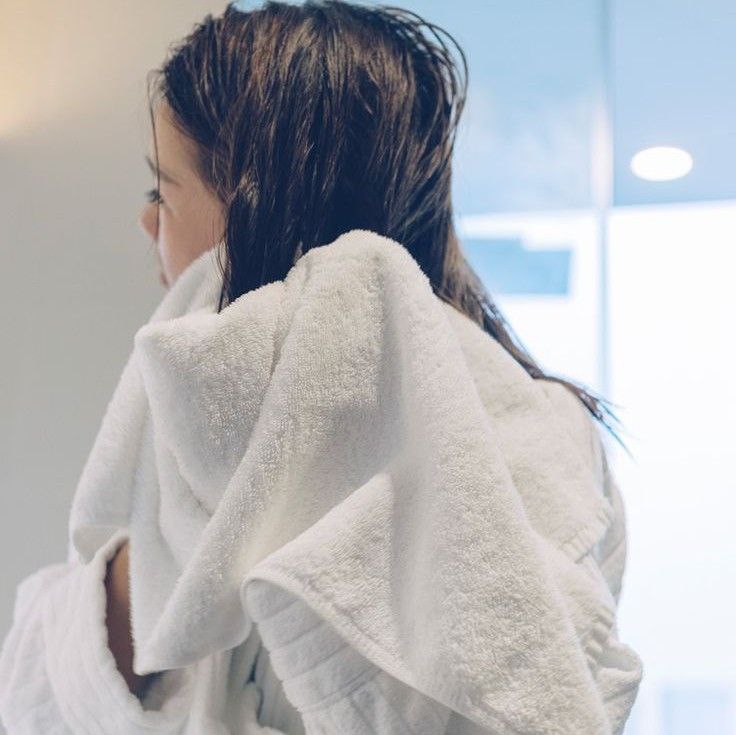 Proper blotting of hair with a soft towel to preserve its structure.